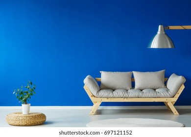 Scandi Style Day Room With A Small Plant, Comfortable Couch, And A Giant Lamp