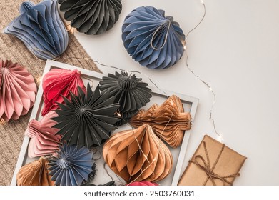 Scandinavian Christmas paper honeycomb, glowing garland and gift box and knitted scarf. Modern Christmas decorations. Christmas card, background. - Powered by Shutterstock