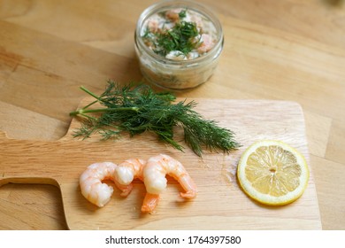 Scandinavian Food - Wooden Chopping Board With Fresh Shrimps, Dill, Slice Of Lemon And Glass Jar Of Traditional Skagen 