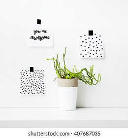 Scandinavian hipster interior design. Note papers on the wall with quote YOU ARE AWESOME and simple hand patterns with succulent or cactus 