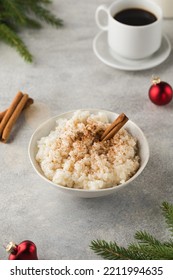  Scandinavian Rice Porridge With Cinnamon In A Bowl Surrounded By Christmas Balls. Breakfast On Christmas Eve.