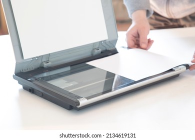 A Scanner For Copying Paper Files.The Person Copies The Files On The Scanner.