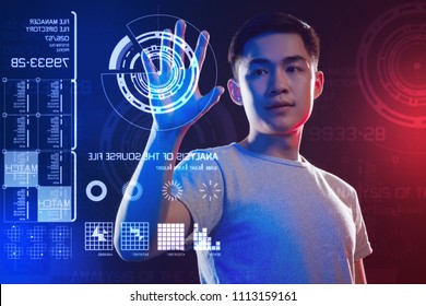 Scanning hand. Professional programmer touching the transparent screen and scanning his hand while using a modern security system