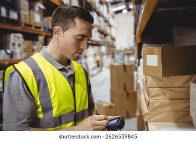 Scanning man using handheld barcode scanner in warehouse aisle, with cardboard boxes, copy space. Industrial, logistics, inventory, distribution, organizational, efficiency, modern