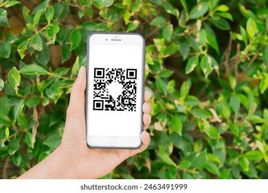 Scanning QR code with mobile smart phone over nature background. Qr code payment, E wallet , cashless technology concept.