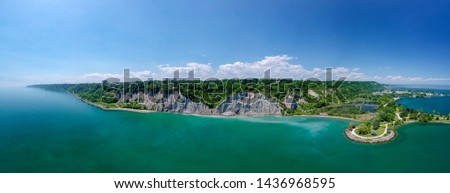 Scarborough Bluffs aerial panorama shot from above with drone, one of the Toronto city attractions. Summer day, high white clay cliffs and turquoise water of Lake Ontario. Wide angle shot.