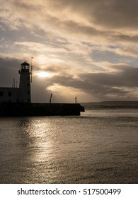 SCARBOROUGH, ENGLAND - NOVEMBER 5: Scarborough lighthouse, early morning, against dramatic sky. In Scarborough, England. On 5th November 2016. - Shutterstock ID 517500499