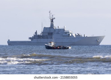 SCARBOROUGH, UNITED KINGDOM - Aug 05, 2017: A Huge Patrol Ship In The Sea With A Small Fishing Vessel Passing Nearby