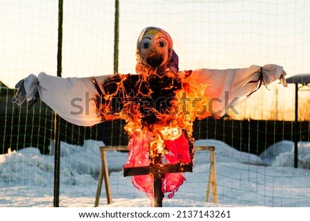 Scarecrow of a woman is on fire. The effigy at the Shrovetide festival is burning.
