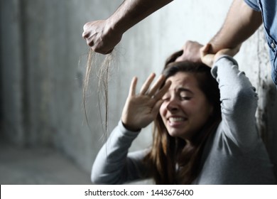 Scared abuse victim being attacked by a mad man in a dark place