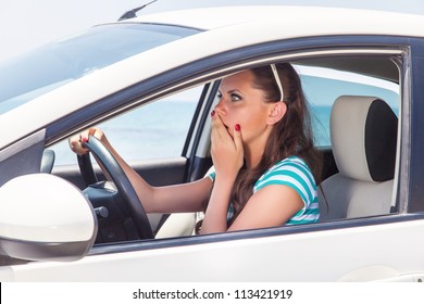 A scared beautiful woman is in the car