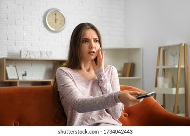 Scared beautiful young woman watching TV at home - Shutterstock ID 1734042443