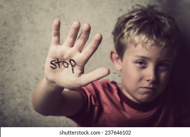 Scared boy with Stop written on his hand