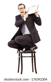 Scared Businessman Climbed On Chair And Swinging With Clipboard Isolated On White Background