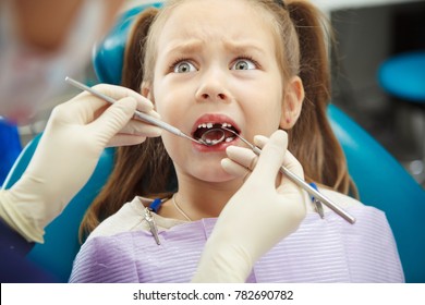 Scared Child Sits At Dentist Chair With Open Mouth