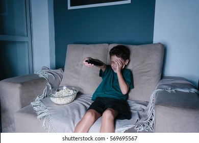 Scared Child Watching Scary Movie On Tv, Sitting On The Couch At Night