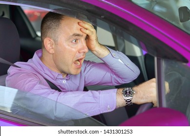 Scared funny looking young man driver in the car. Side window view of inexperienced anxious motorist. Young man driving a car shocked about to have traffic accident, windshield view.