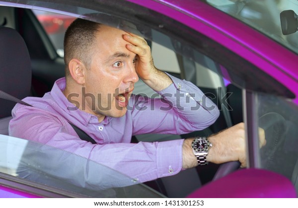 Scared\
funny looking young man driver in the car. Side window view of\
inexperienced anxious motorist. Young man driving a car shocked\
about to have traffic accident, windshield\
view.