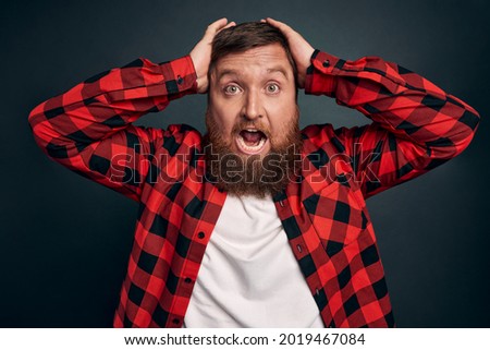 Scared guy in panic grab head and screaming, stare camera popped eyes from fright, afraid something, trembling fear standing stupor shouting terrified, standing grey background frustrated.
