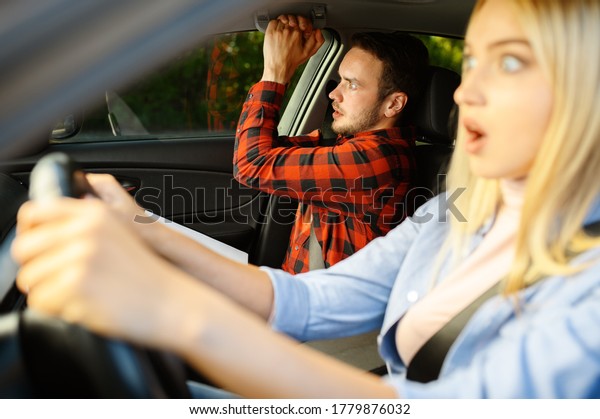 Scared lady\
and instructor in car, driving\
school