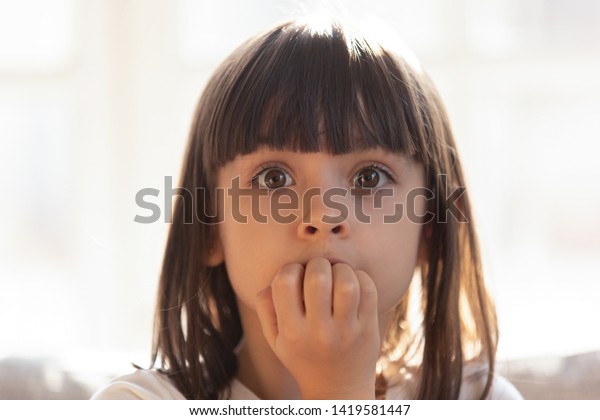 おびえる少女は 何かを心配しているカメラをかむ爪を見 怯えた幼稚な子どもが口を丸め ストレスを受けた子どもは 家に残されたままの恐怖や恐怖を感じる の写真素材 今すぐ編集