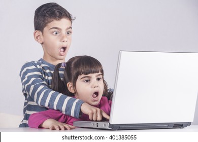 Scared little kids react while using a laptop. Internet safety for kids concept. Toned image with selective focus