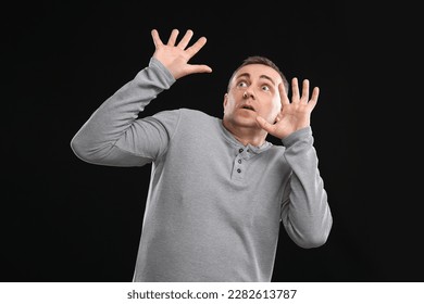 Scared mature man on black background - Shutterstock ID 2282613787