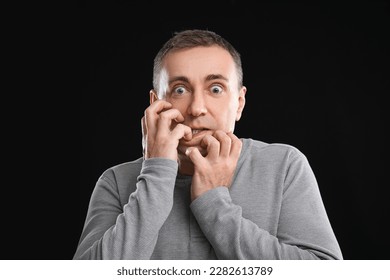 Scared mature man on black background, closeup - Shutterstock ID 2282613789