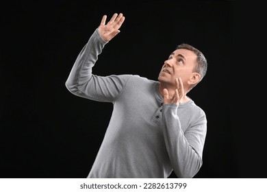 Scared mature man on black background - Shutterstock ID 2282613799