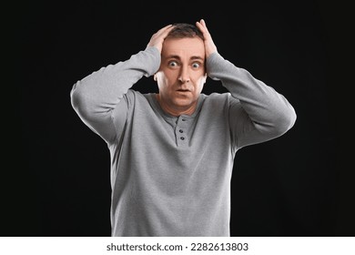 Scared mature man on black background - Shutterstock ID 2282613803