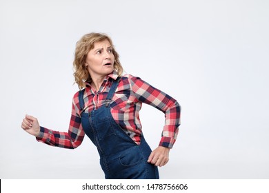 Scared Mature Woman Running Away Isolated On White Background. Studio Shot