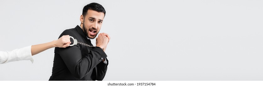 Scared Muslim Groom In Handcuffs Looking At Camera Near Bride Isolated On Grey, Banner