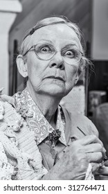 Scared Old Woman With Crochet In Living Room