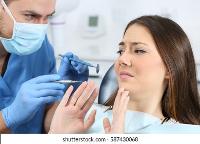 Scared Patient With A Doctor Trying To Examine Her In A Dentist Office