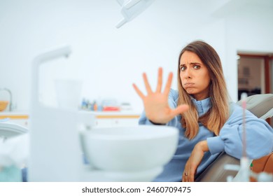 
Scared Patient Making Stop Gesture Sitting in the Dental Chair 
Fearful woman suffering a panic attack in a dentist office 
 - Powered by Shutterstock