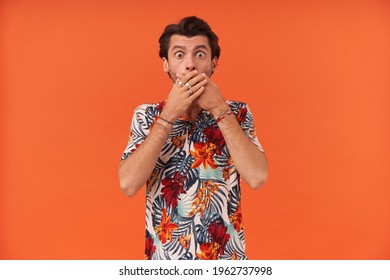 Scared Shocked Young Man With Bristle In Colourful Shirt Covered His Mouth By Hands And Feels Frightened Over Orange Background