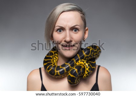 Scared woman with anaconda on her neck