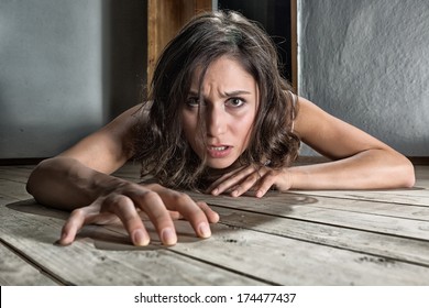 Scared Woman Crawling On The Floor Of A Derelict House