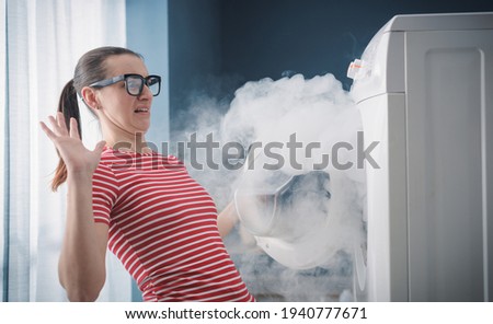 Scared woman dealing with a broken burning appliance at home