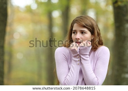Scared woman looking at side walking alone in a park