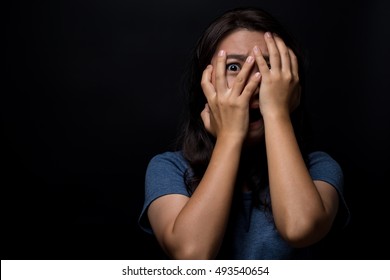 Scared woman on isolated black background