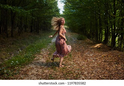 Scared Woman Running Through The Forest