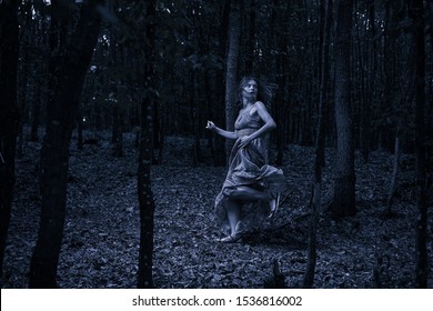 Scared Woman Running Through The Forest