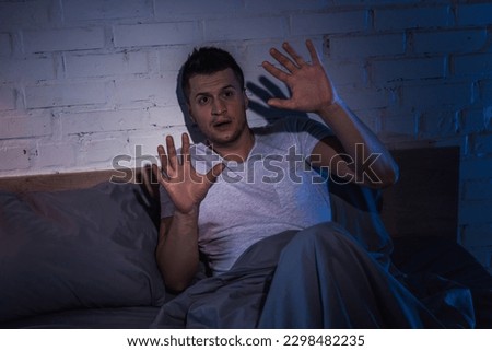 scared young man with ptsd having nightmares and insomnia at night