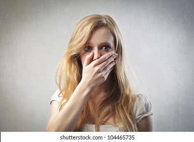 Scared Young Woman With Her Hand On Her Mouth