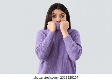 Scared young woman on grey background - Shutterstock ID 2311328207
