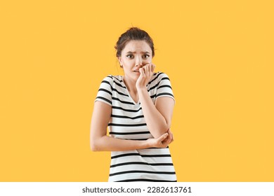 Scared young woman on yellow background - Shutterstock ID 2282613761