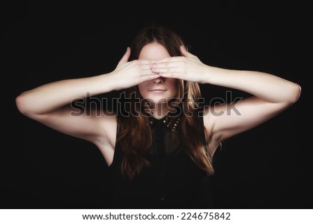 Scared. young woman teen girl covering her eyes on black. No see evil