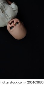 Scary Broken Baby Doll On Black Background. Scary Baby Doll. Creepy Baby Doll.