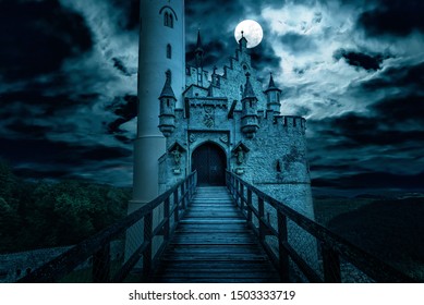 Scary Castle At Night, Haunted Place On Halloween. Dark Scene With Gothic Castle, Gloomy Palace In Full Moon. Spooky View Of Mystery Mansion, Castle And Old Footbridge In Germany. Horror Concept.